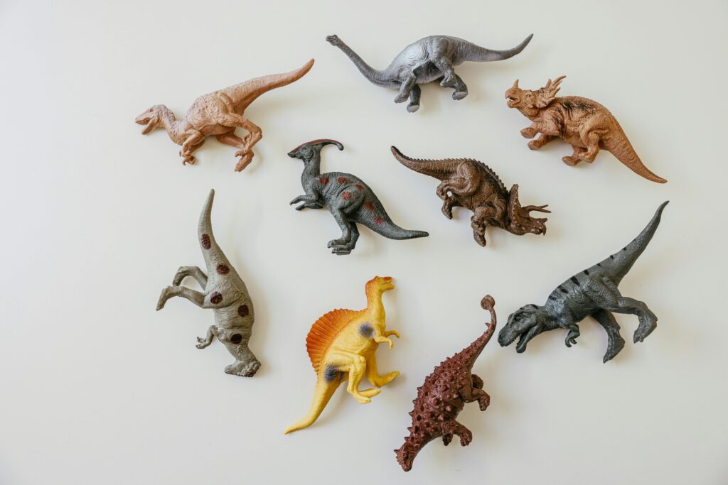 A playful flat lay of colorful dinosaur toy figures on a light background.
